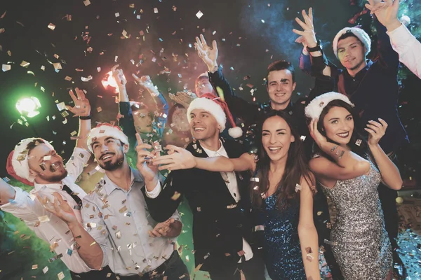 Young people have fun at a New Year's party. Around them flies confetti. — Stock Photo, Image