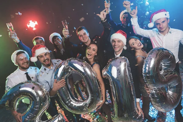 Os jovens na festa de Ano Novo estão posando com grandes bolas infláveis brilhantes na forma de números 2019 . — Fotografia de Stock