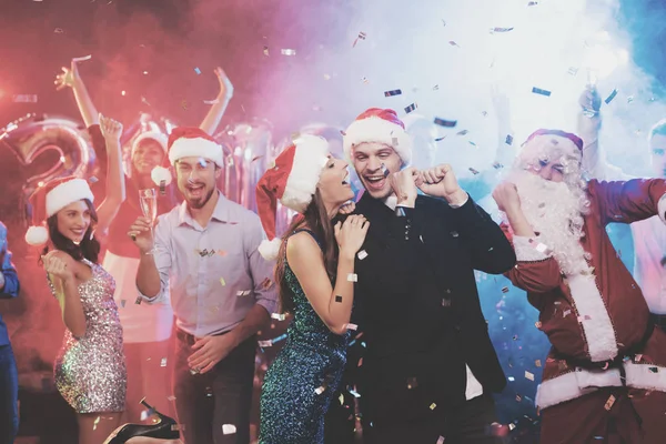 Young couple having fun at New Year's party. They do selfie on a smartphone. — Stock Photo, Image