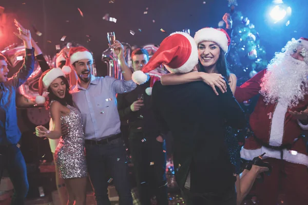 Casal jovem dançando abraçando. Têm bonés de Pai Natal. . — Fotografia de Stock