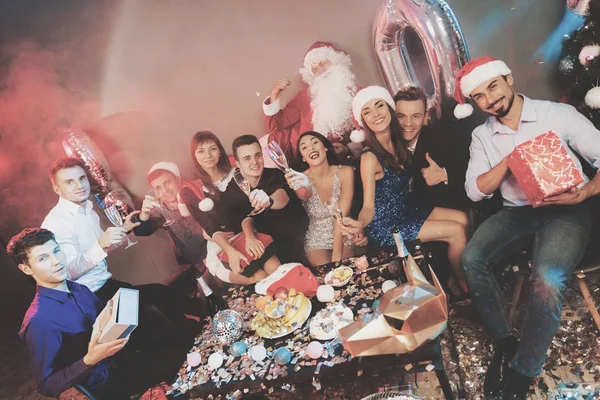 Feliz compañía en la fiesta de Año Nuevo. La gente bebe champán e intercambian regalos. . — Foto de Stock