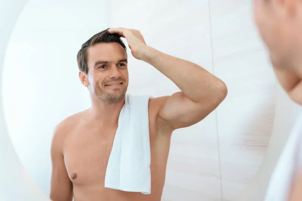 Un uomo si alza in bagno la mattina e si guarda allo specchio. Sorride. . — Foto Stock