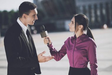Business man giving an interview to a woman clipart