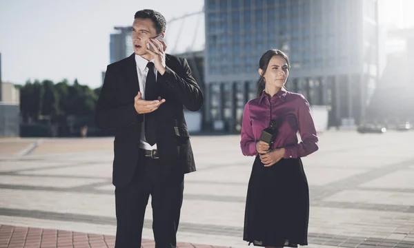 On the street a man talks on the iPhone, next to him stands a journalist with a microphone — Stock Photo, Image