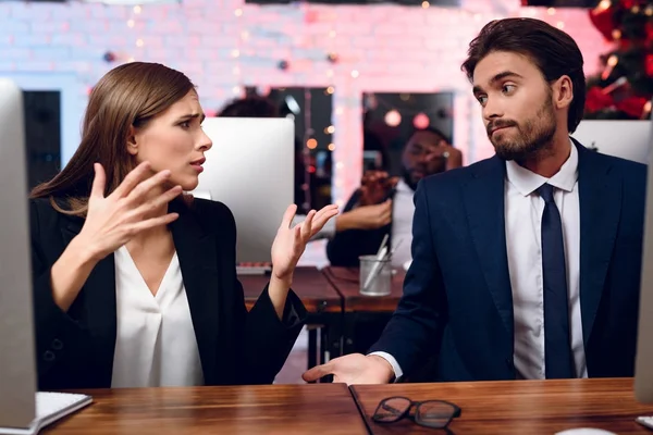 A man and a woman are working in the office on the eve of the new year. They are actively discussing something — Stock Photo, Image