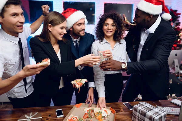 Ludzie przygotowują się na spotkanie noworoczne w biurze. Posiadają okulary z szampana i pizza. — Zdjęcie stockowe