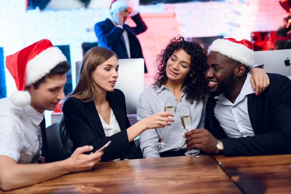 Ludzie przygotowują się na spotkanie noworoczne w biurze. Siedzieć z kieliszków szampana w ręku i zabawy — Zdjęcie stockowe