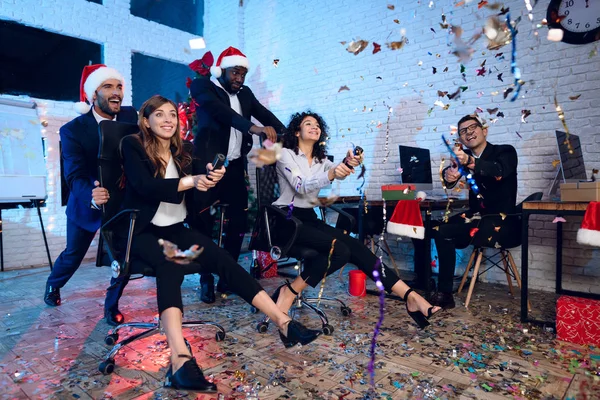 Los trabajadores de oficina celebran un nuevo año en la oficina. Están entreteniendo y lanzando confeti. Se están divirtiendo. . — Foto de Stock