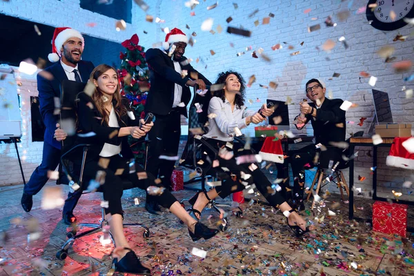 Los trabajadores de oficina celebran un nuevo año en la oficina. Están entreteniendo y lanzando confeti. Se están divirtiendo. . — Foto de Stock