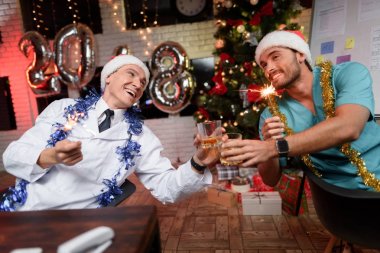 İki doktor ofiste Yılbaşı kutlamak. Onlar gözlük viski ve ellerinde bergal ışıkları ile tıklatması.