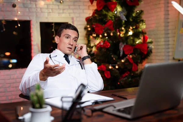 Lékař pracuje na nový rok. Mluvil po telefonu. — Stock fotografie
