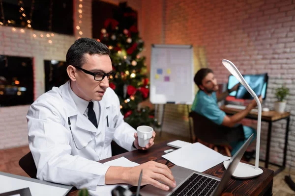 Лікар працює напередодні нового року. Він спілкується з колегою, який показує йому x-Ray фотографія. — стокове фото