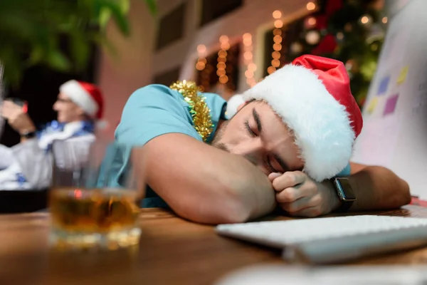 Lékař pracuje na nový rok. Boredly položí na stůl. Nedaleko je sklenku whisky. — Stock fotografie