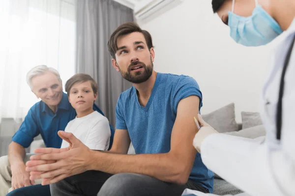 Una enfermera hace una vacuna para un hombre. El hombre está preocupado, porque tiene miedo de las inyecciones . — Foto de Stock