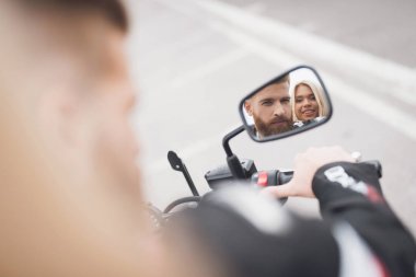 Genç bir adam ve bir modern elektrikli motosiklet üzerinde oturan kız.