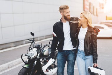 Genç bir adam ve bir kız bir elektrikli motosiklet duruyorsun.