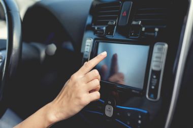 Genç bir kız düğmeleri elektrikli araç kontrol cihazları üzerinde presler.