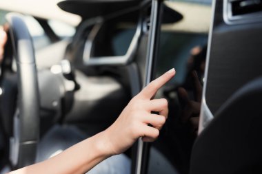 Genç bir kız düğmeleri elektrikli araç kontrol cihazları üzerinde presler.