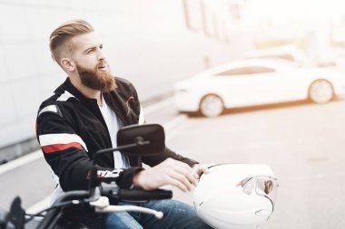 Sakallı genç bir adam onun elektrikli motosiklet üzerinde oturur.