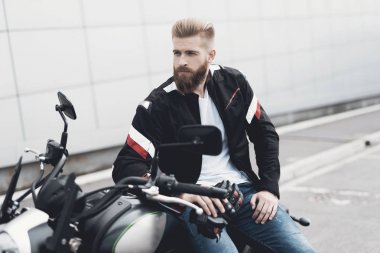 Sakallı genç bir adam onun elektrikli motosiklet üzerinde oturur.