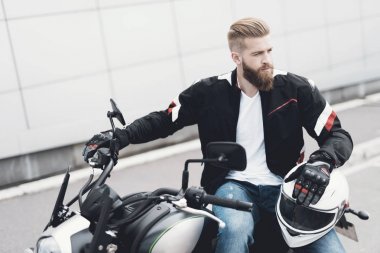 Sakallı genç bir adam onun elektrikli motosiklet üzerinde oturur.
