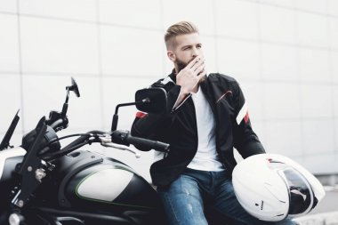 Sakallı genç bir adam onun elektrikli motosiklet üzerinde oturur.