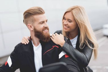 Genç bir adam ve bir modern elektrikli motosiklet üzerinde oturan kız.