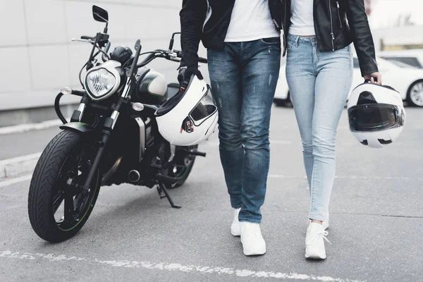 Un jeune homme et une fille se tiennent près d'une moto électrique . — Photo