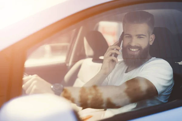 Un giovane con la barba siede al volante di un veicolo elettrico . — Foto Stock