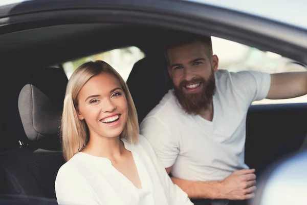 Um jovem casal está sentado na cabine de um confortável carro elétrico moderno . — Fotografia de Stock