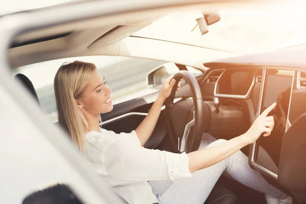 若い女の子が電気自動車制御装置のボタンを押す. — ストック写真