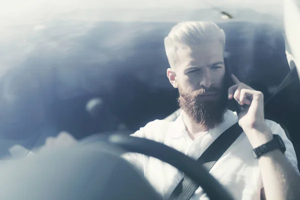 Un joven con barba se sienta al volante de un vehículo eléctrico . —  Fotos de Stock