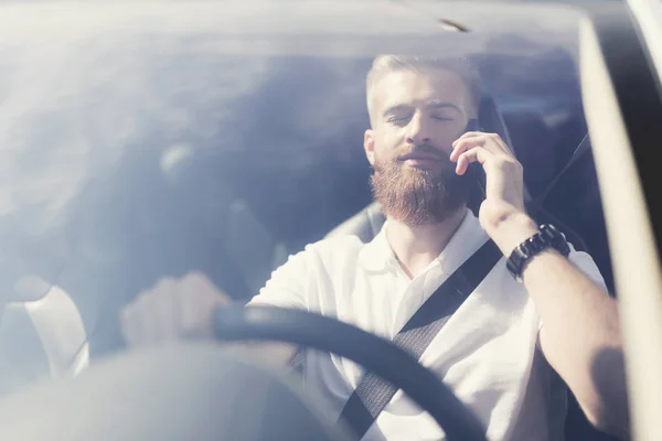 Un joven con barba se sienta al volante de un vehículo eléctrico . — Foto de Stock