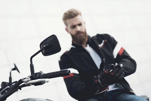 A young guy with a beard sits on his electric motorcycle. — Stock Photo, Image