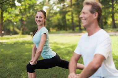 Erkek ve kadın ısınma doğada yapıyor. Çift doğa spor yapıyor.