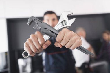 Tesisatçı mutfakta poz. O iki anahtarı geçti ve gülümsedi.