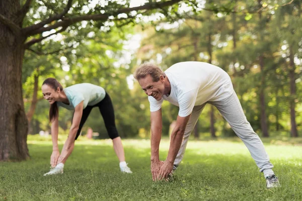 Paar macht körperliche Übungen in der Natur. Gemeinsam machen sie die Pisten. — Stockfoto