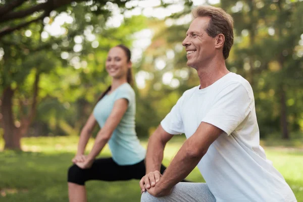 Mann und Frau beim Aufwärmen in der Natur. Paar treibt Sport in der Natur. — Stockfoto