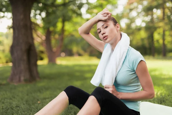 Egy nő ül a jóga szőnyeg és pihenő edzés után. Háta mögött van a kék labdát, jóga. — Stock Fotó