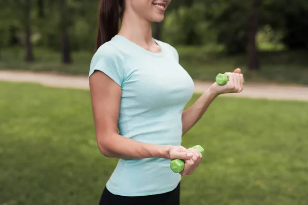 Chica en el parque haciendo ejercicios con pesas — Foto de Stock