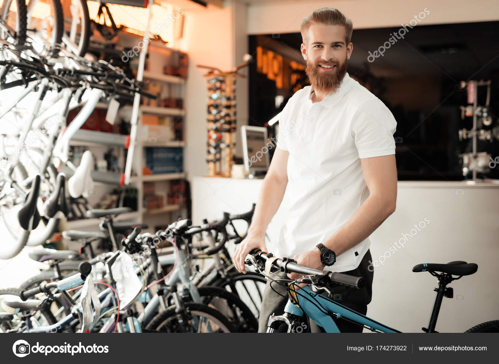 Un vendedor en una tienda de bicicletas posa cerca de una