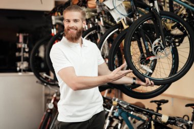 Bir satıcı bir bisiklet dükkanında bir bisiklet teşkil etmektedir..