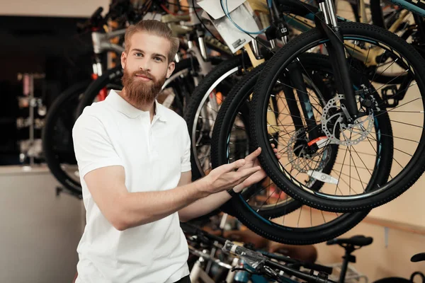 Verkäufer in einem Fahrradgeschäft posiert neben einem Fahrrad. — Stockfoto