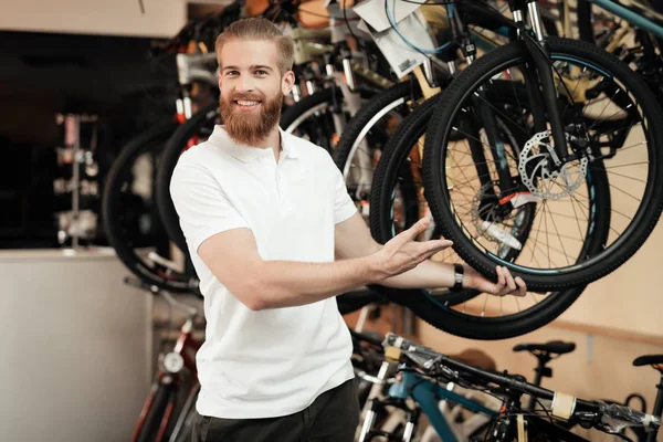 Продавец в магазине велосипедов позирует рядом с велосипедом . — стоковое фото