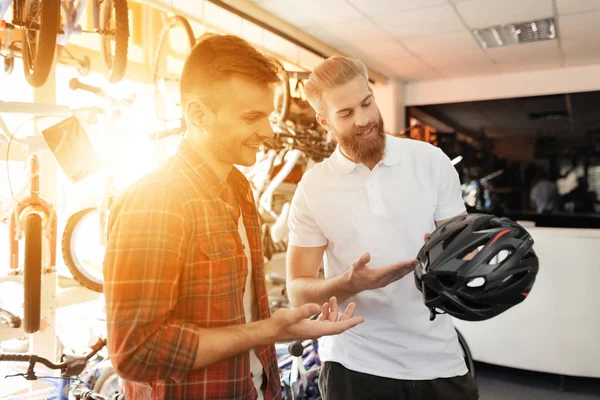 Adam satıcının alıcı Bisiklet kask rides gösterir. — Stok fotoğraf