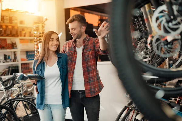 Una joven pareja vino a la tienda de bicicletas para elegir una bicicleta nueva . — Foto de Stock