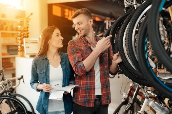 Un jeune couple est venu au magasin de vélos pour choisir un nouveau vélo . — Photo