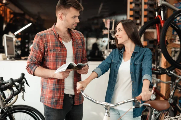 Un jeune couple est venu au magasin de vélos pour choisir un nouveau vélo . — Photo