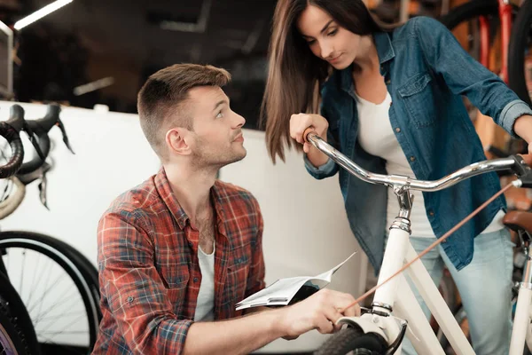 Un jeune couple est venu au magasin de vélos pour choisir un nouveau vélo . — Photo