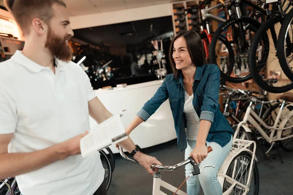 Une jeune fille choisit un vélo de ville dans son magasin . — Photo